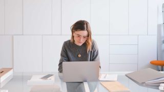 mejor alojamiento web: mujer en la computadora portátil