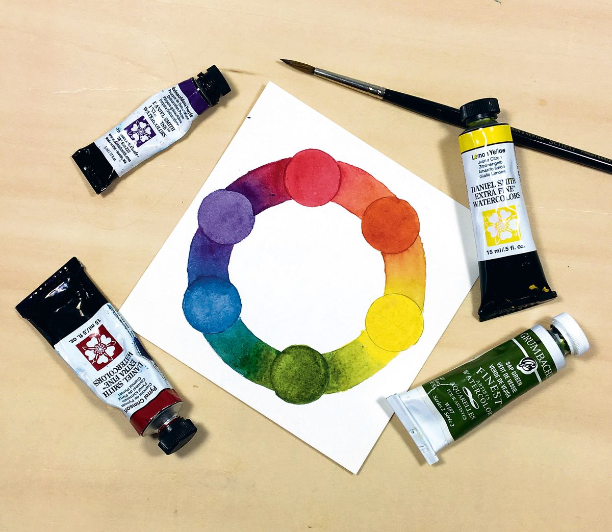 Akvarell színes kerék megfelelő festékcsövekkel körülvéve