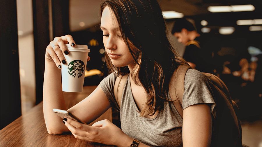 Mädchen mit Kaffee und Smartphone