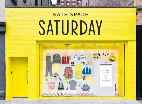 Svijetložuta trgovina s odjećom Kate Spade za subotnju odjeću uredno zakačenom za zid